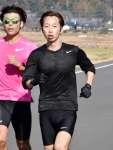 チームメートとロード走で汗を流す山崎遊馬さん（右）＝伊佐市大口平出水