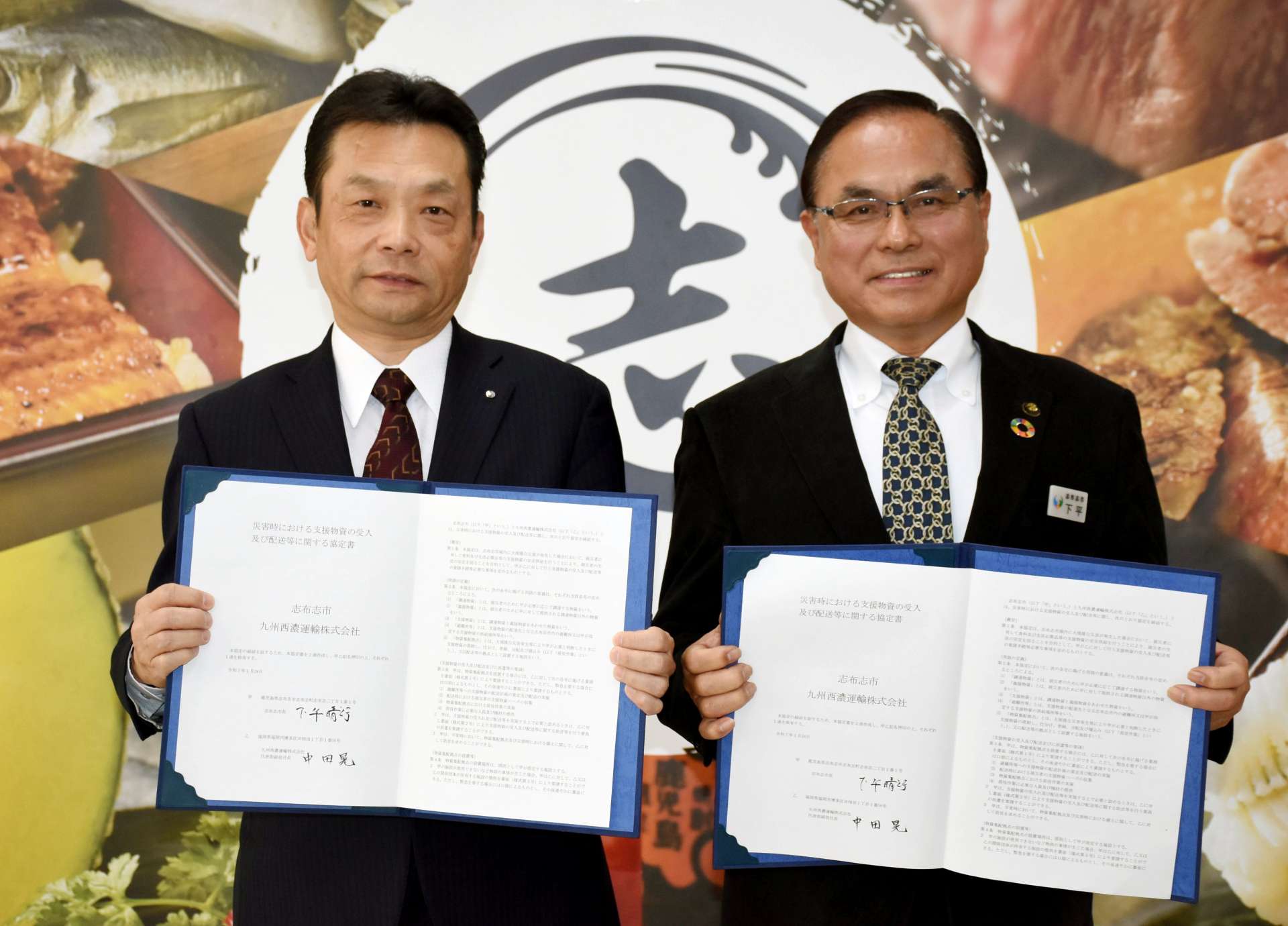 災害時の支援物資受け入れ・配送の協定を結んだ九州西濃運輸の中田晃社長（左）と下平晴行市長＝志布志市役所