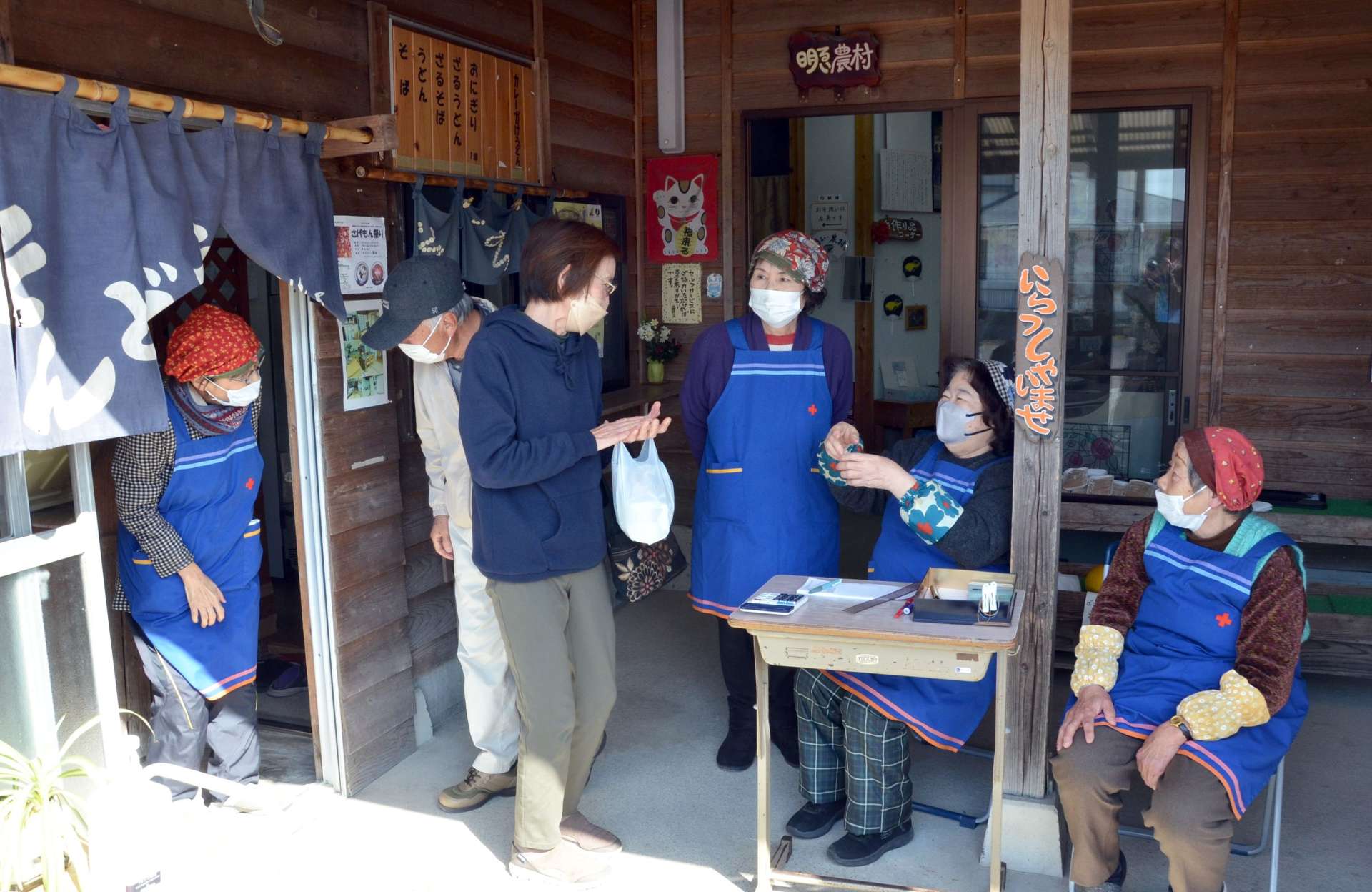 「明るい農村」最後の営業日に来店客と交流する女性スタッフら＝日置市吹上