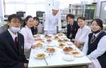 高校生にフランス料理のレシピを伝授した鹿島匡人シェフ（中央）＝垂水市の垂水高校