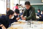 大富潤教授（右）の説明を聞きながらナミクダヒゲエビを観察する児童＝垂水市の協和小学校