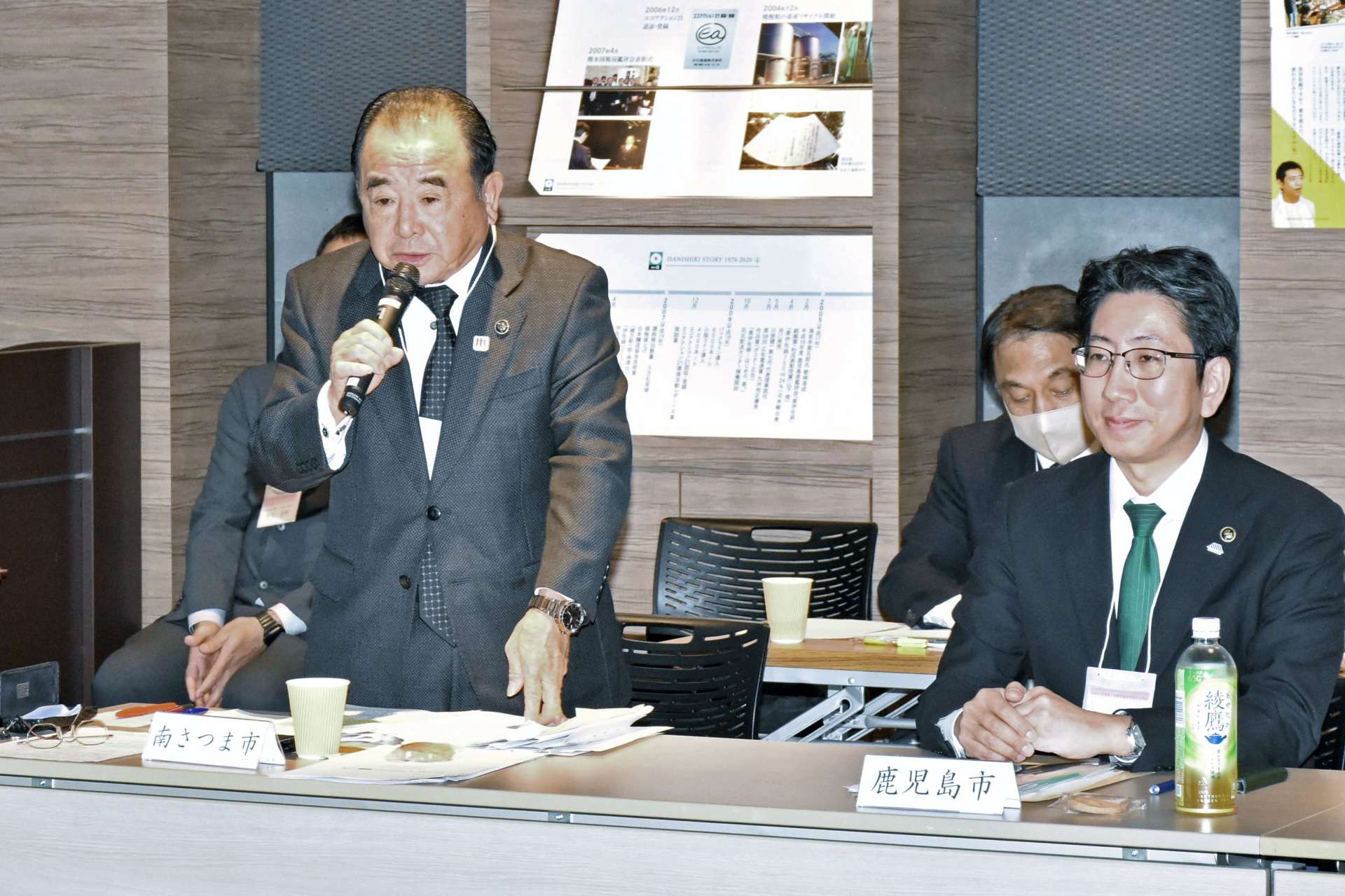 再任しあいさつする本坊輝雄会長（左）＝４日、伊佐市菱刈田中