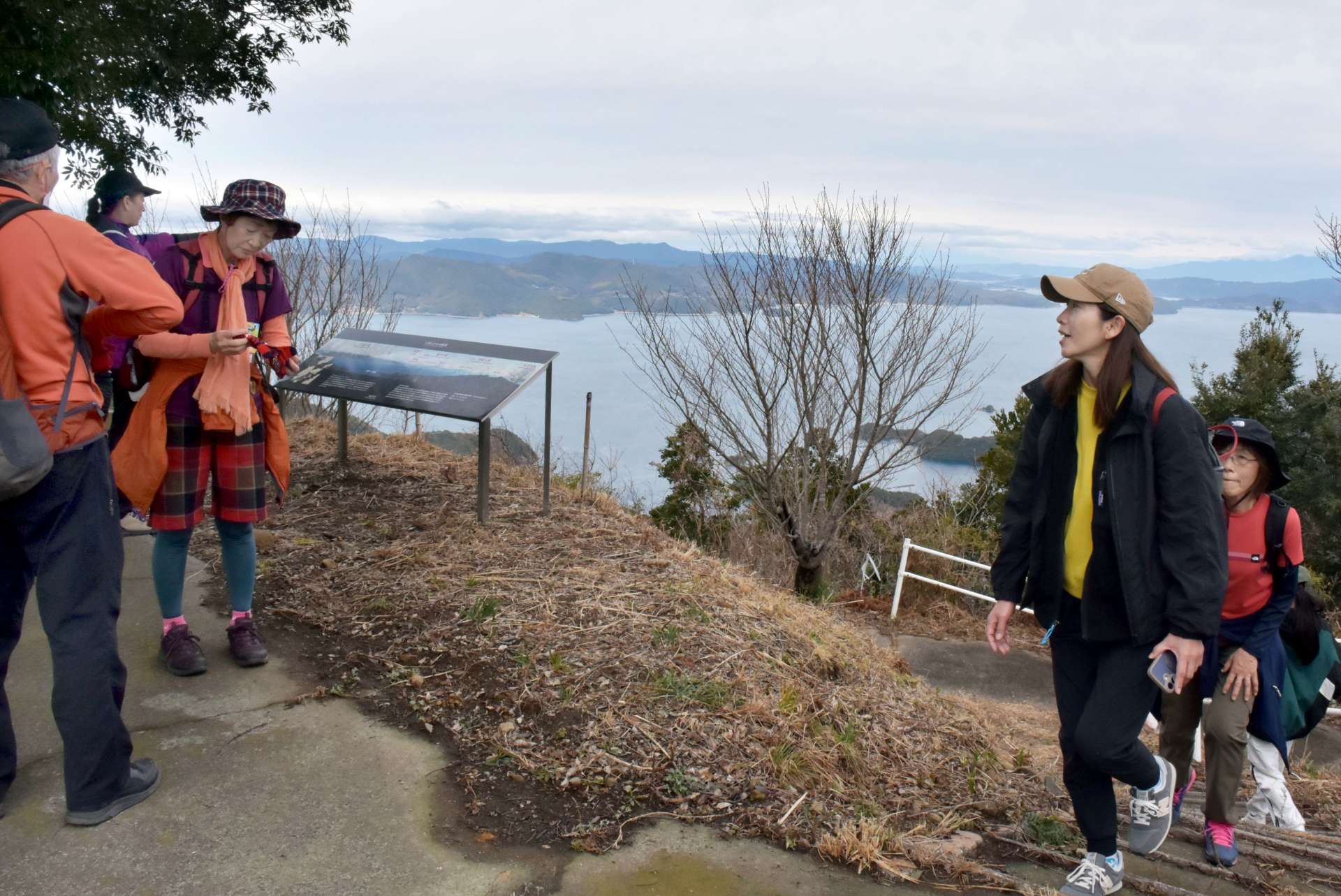 頂上で天草諸島や雲仙普賢岳の眺めを楽しむ獅子島ウオーク参加者＝長島町獅子島の七郎山