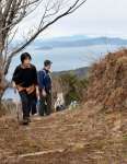 天草諸島や雲仙普賢岳を望む山道を登る獅子島ウオーク参加者＝長島町獅子島の七郎山
