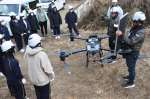 苗木運搬に使う大型ドローンの説明に耳を傾ける都城東高校生＝都城市蔵満町