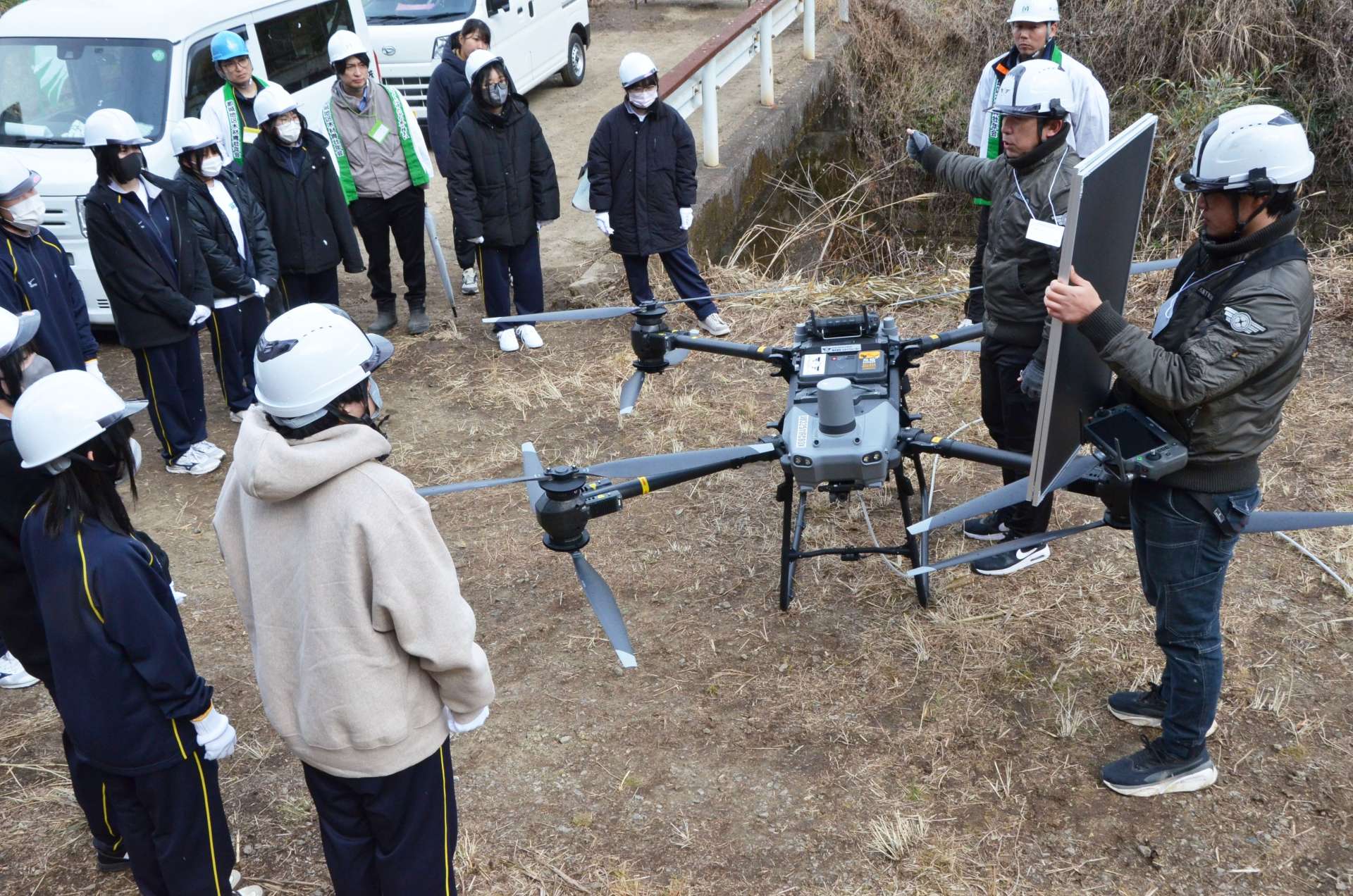 苗木運搬に使う大型ドローンの説明に耳を傾ける都城東高校生＝都城市蔵満町