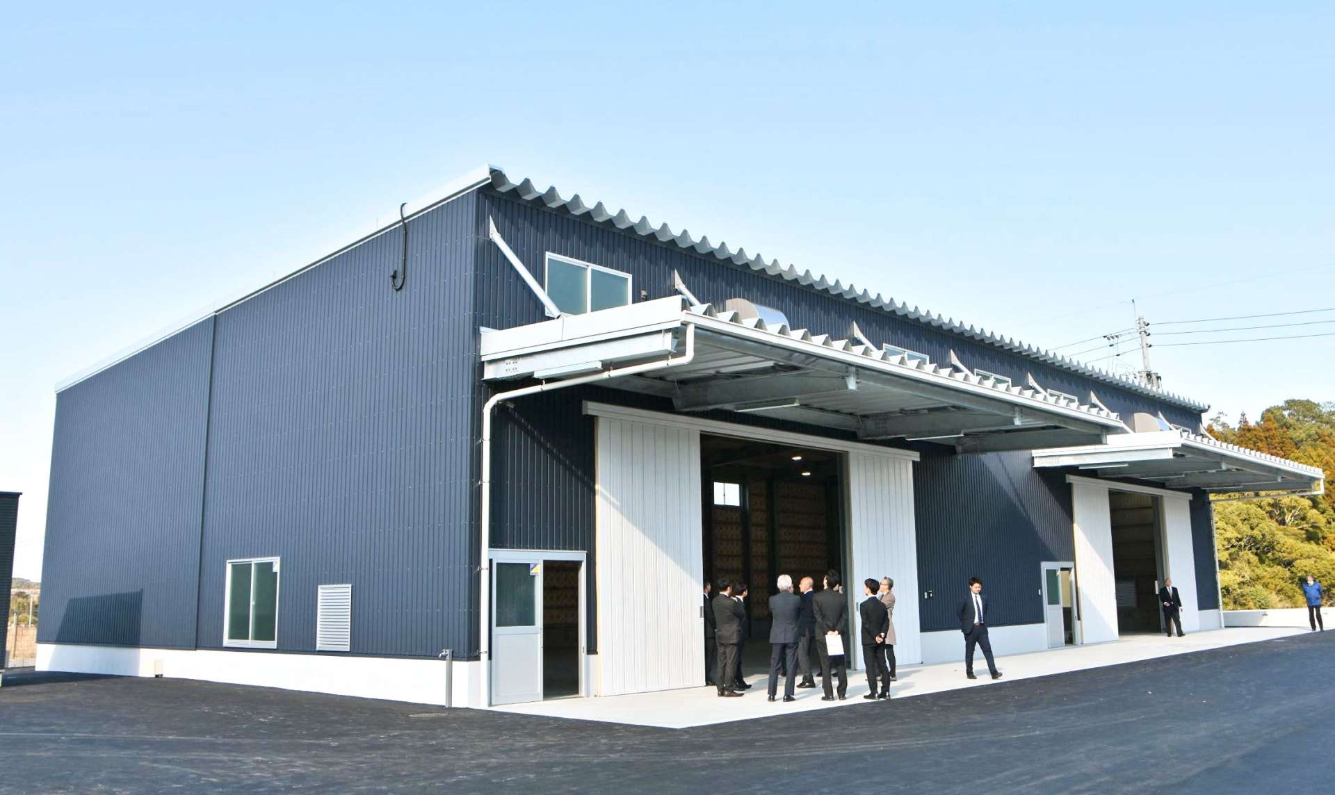完成した新倉庫を見学する関係者ら＝１４日、薩摩川内市