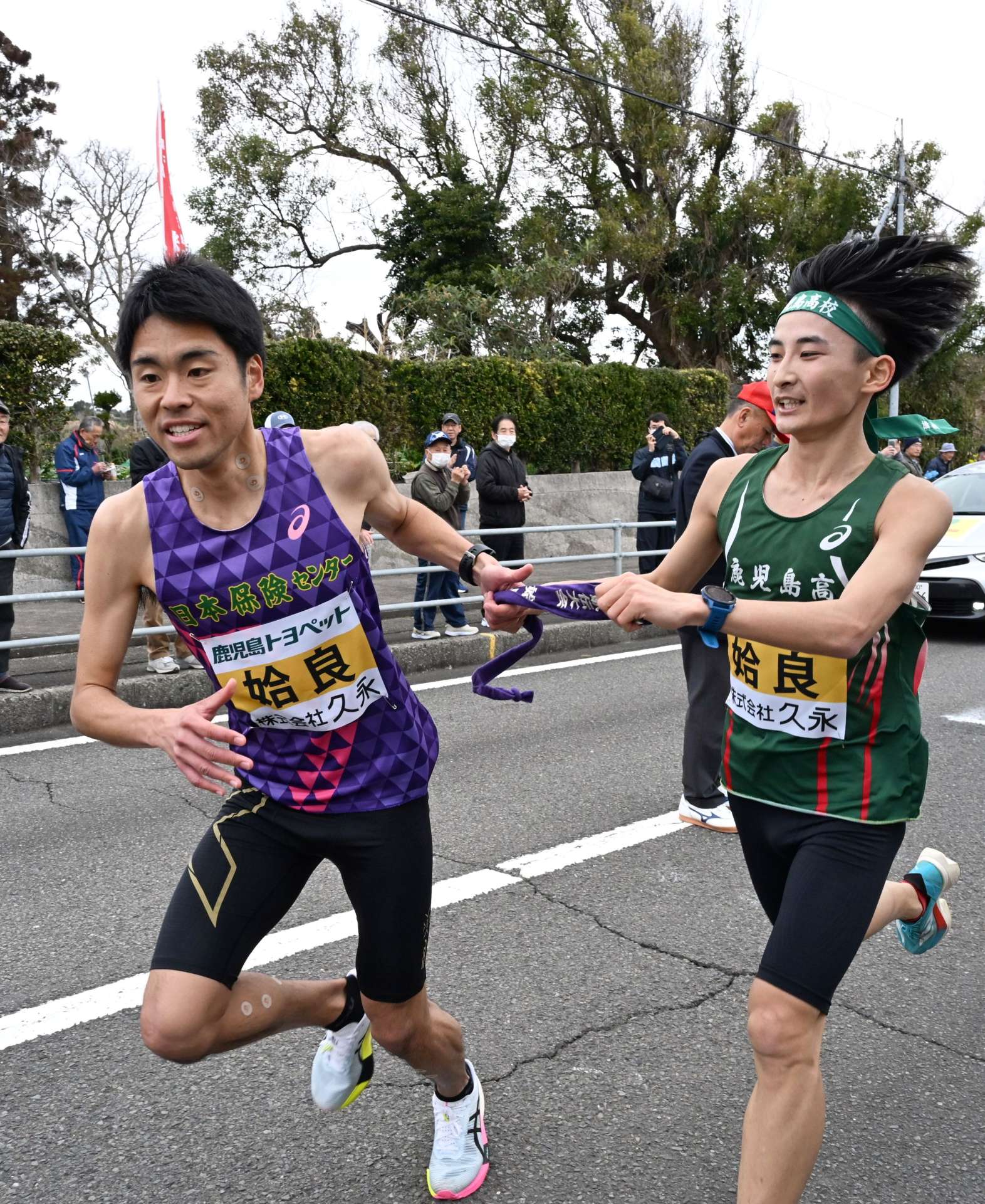 第７中継所、姶良・中園勁翔（右）が樗木颯瑳にたすきを渡す＝南九州市