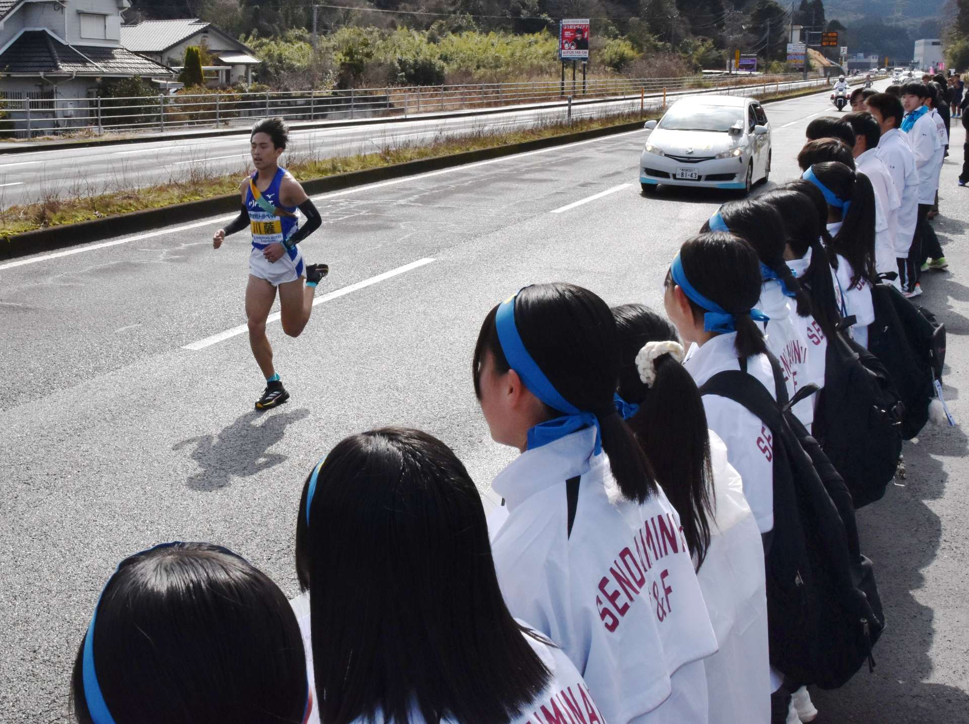 新コースの沿道で、先輩の川薩チーム・西手新陽選手に声援を送る川内南中学校の陸上部員たち＝１６日、薩摩川内市