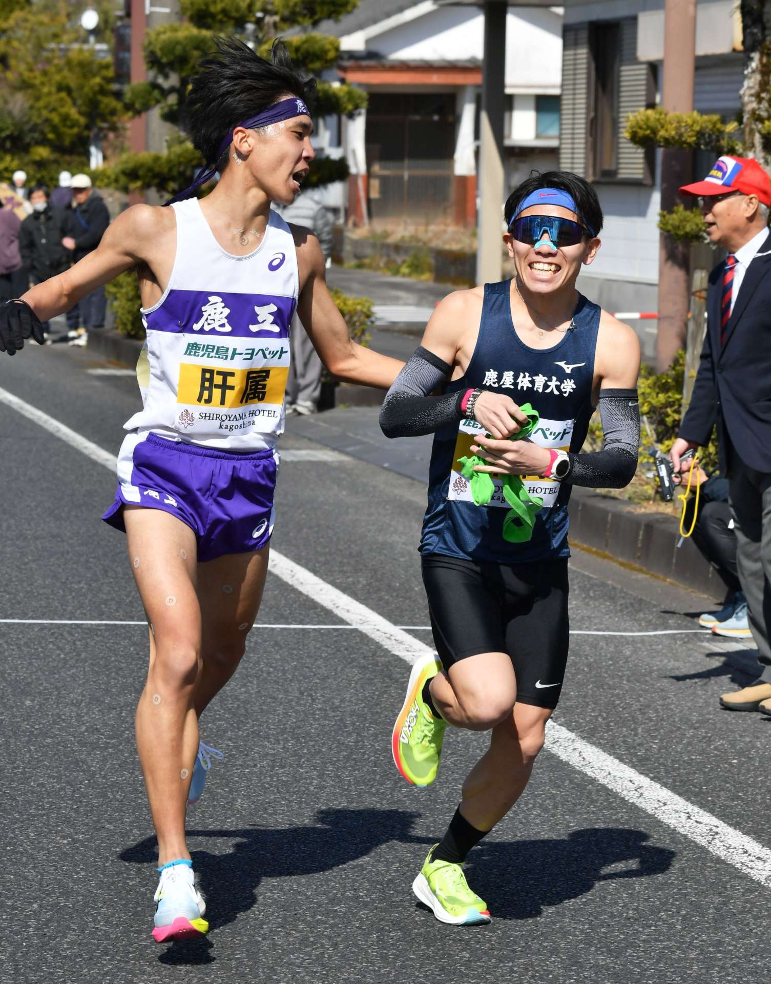 区間賞の走りを見せた肝属・橋口晋賀（左）がアンカーの大島大青にたすきをつなぐ＝肝付町