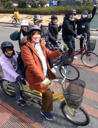 タンデム自転車の練習をする親子連れら＝南さつま市の吹上浜海浜公園