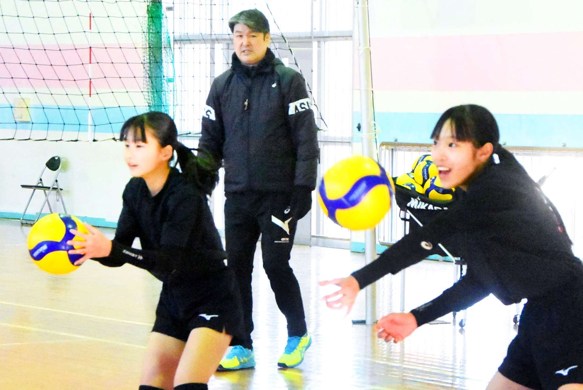 バレー部の練習を見守る植田辰哉さん（中央）＝南さつま市の万世中学校