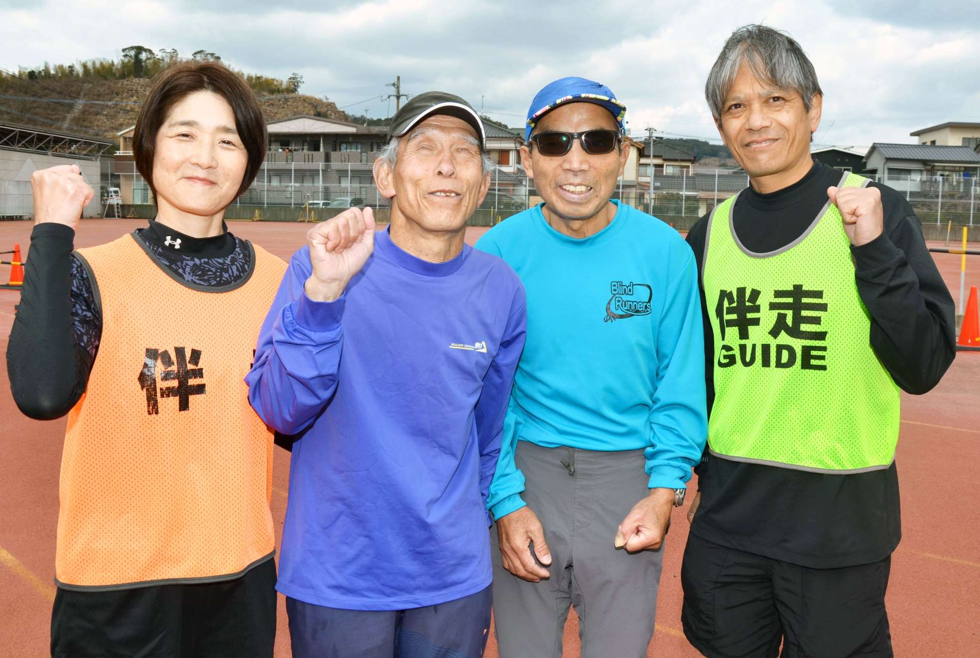 「名前を呼んでくれる応援がうれしい」と語る、鹿児島マラソンに参加するブラインドランナーズの丸田廣美さん（左から２人目）と丸野光男さん（同３人目）ら＝鹿児島市のハートピアかごしま