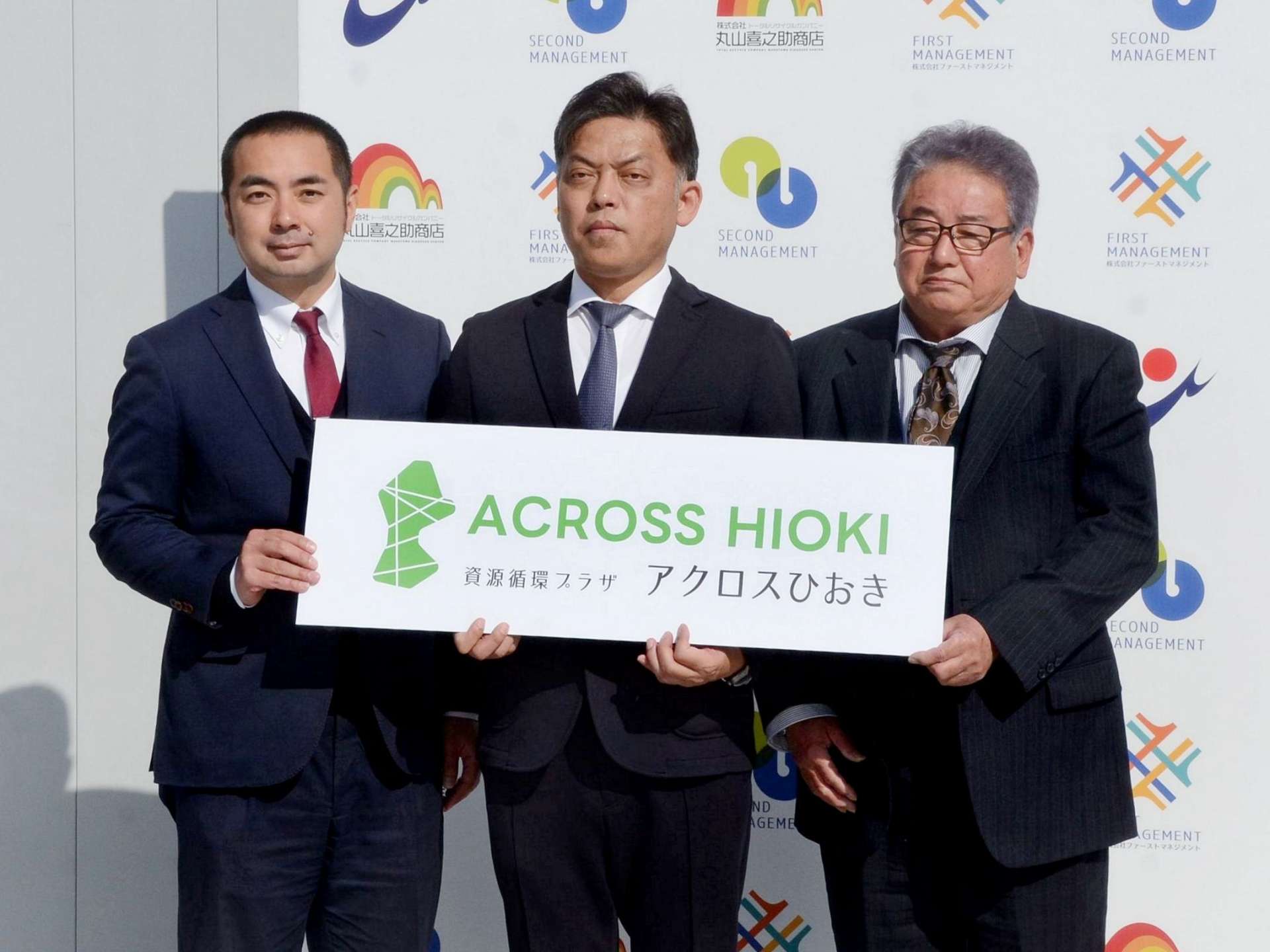 「資源循環プラザ　アクロスひおき」の正式名称を発表する丸山喜之助商店の丸山明紀社長（中央）ら＝２７日、日置市伊集院の同社