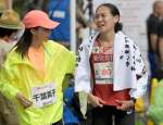 女子２位でゴールし千葉真子さん（左）からねぎらいを受ける池満綾乃（鹿銀）＝鹿児島市山下町