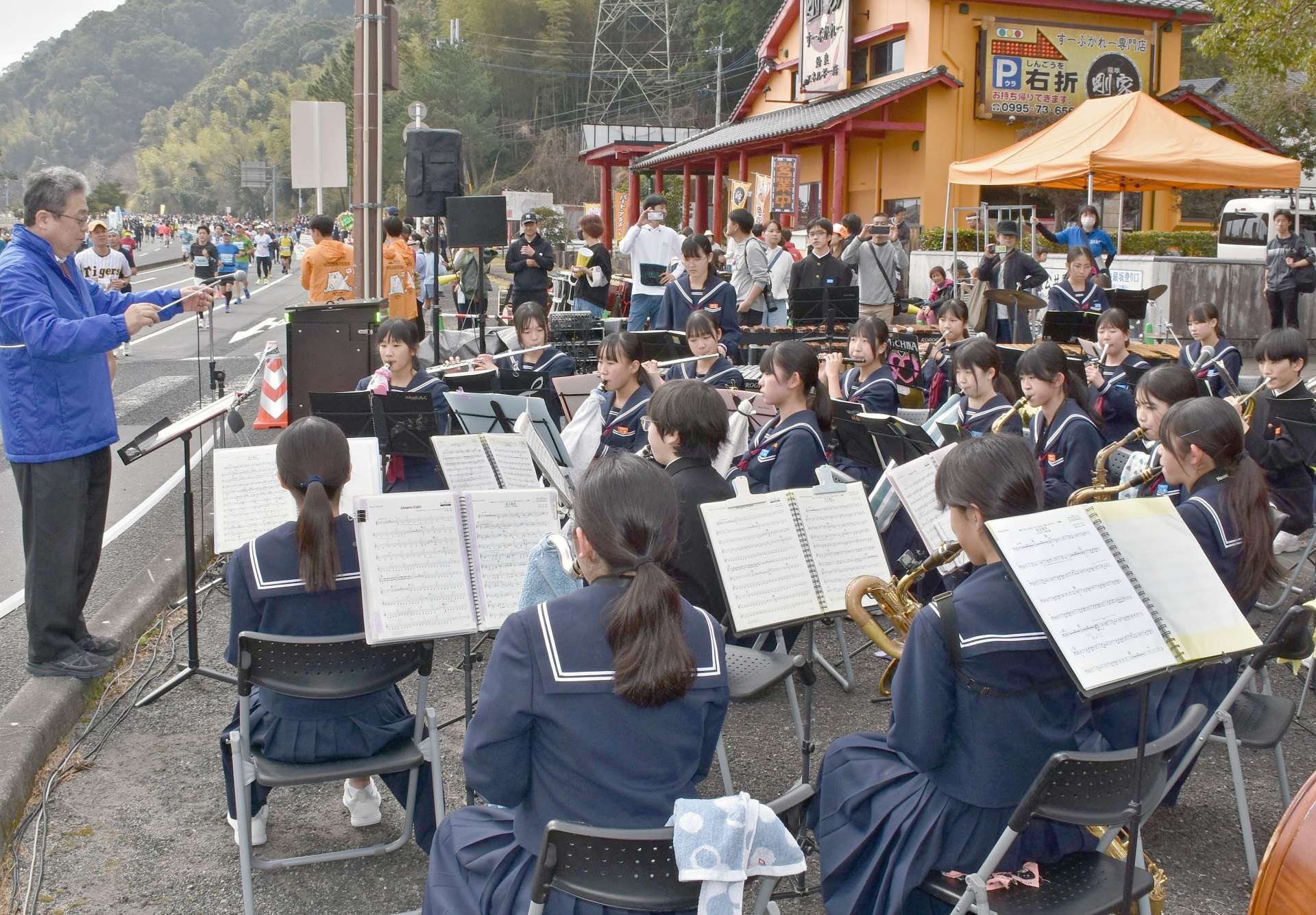 沿道で演奏する重富中学校吹奏楽部＝２日、姶良市脇元
