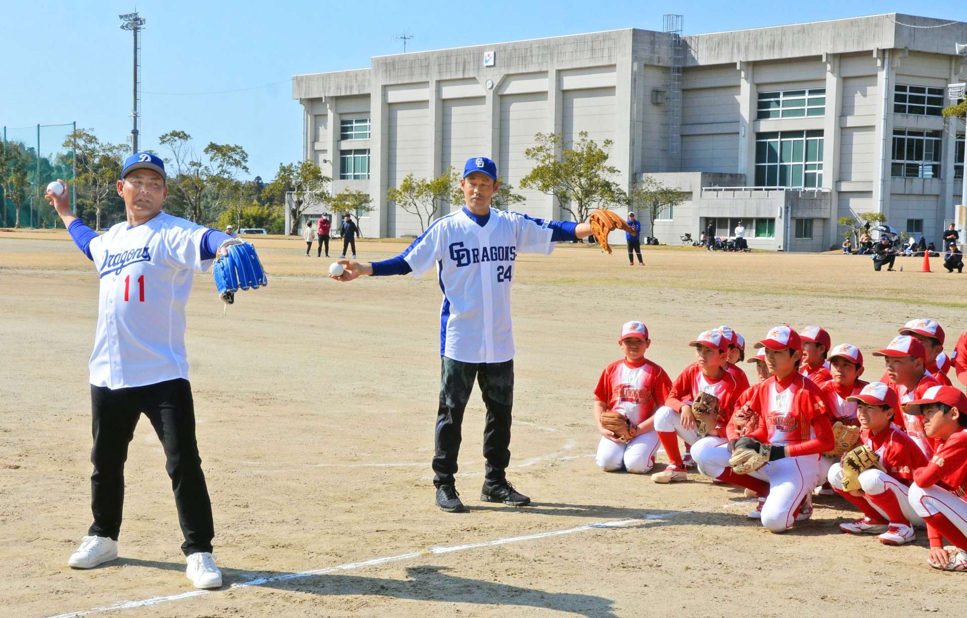 子どもたちに、投球のコツを指導する川上憲伸さん（左）ら＝日置市日吉