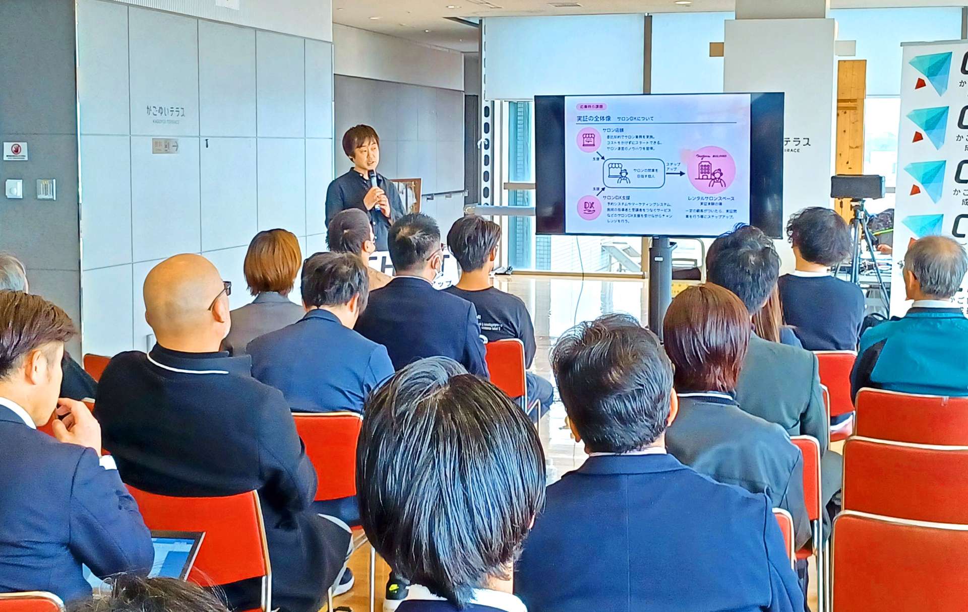 美容サロン運営のビジネスモデル実証について報告する野崎弘幸さん＝６日、鹿児島県庁
