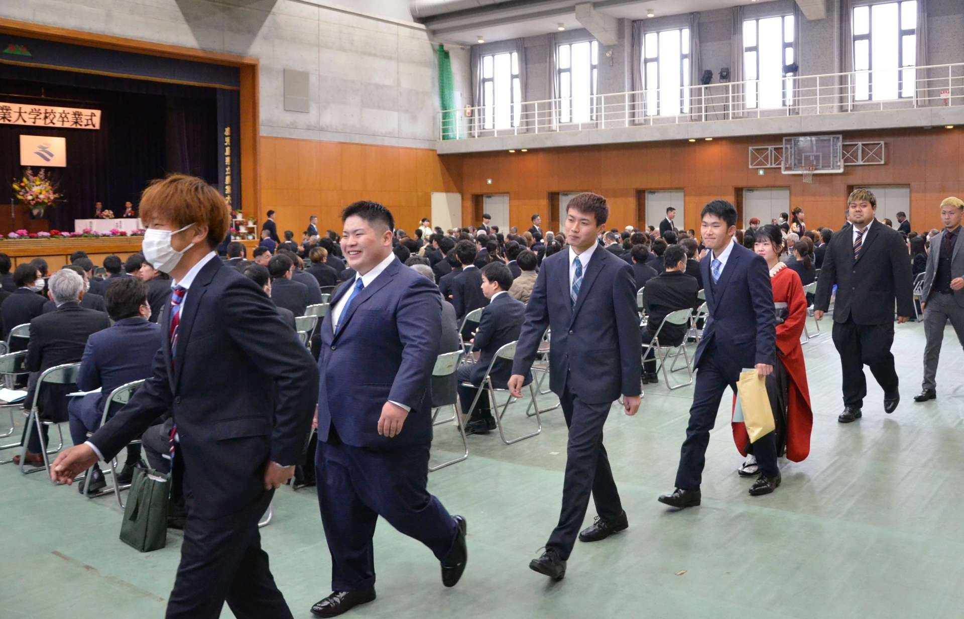 職員らに見送られ退場する卒業生＝１０日、日置市の鹿児島県立農業大学校
