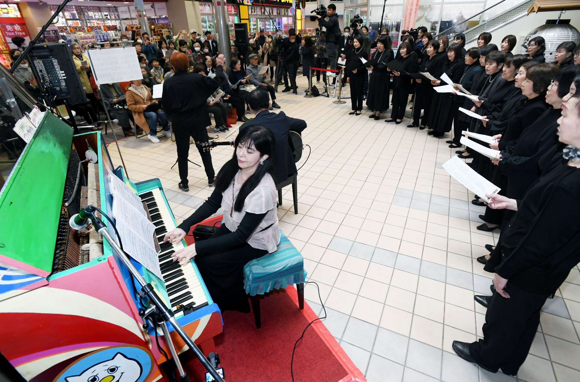 復興を願いピアノの音色と歌声を響かせる参加者＝１１日午後２時５０分、鹿児島市中央町（桑元伸二撮影）