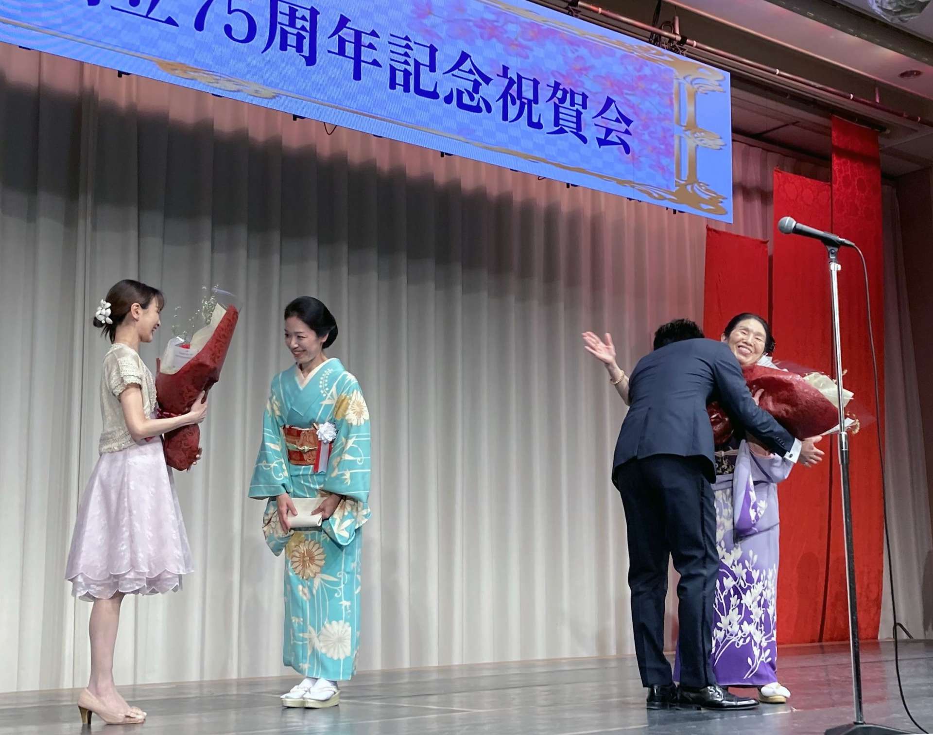 花束を受け取る白鳥バレエの白鳥見なみ主宰（右端）と白鳥五十鈴団長（左から２人目）＝９日、鹿児島市の城山ホテル鹿児島