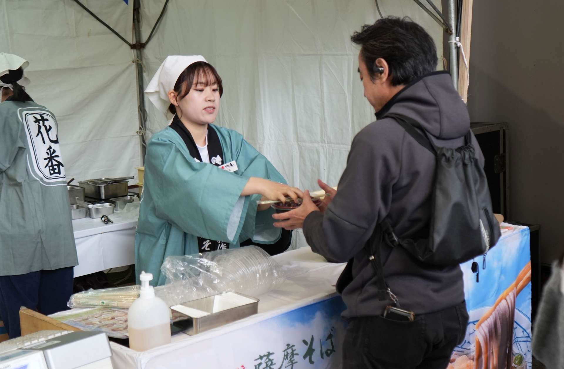 そばを受け取る客＝１４日、鹿児島市のＪＲ鹿児島中央駅前アミュ広場