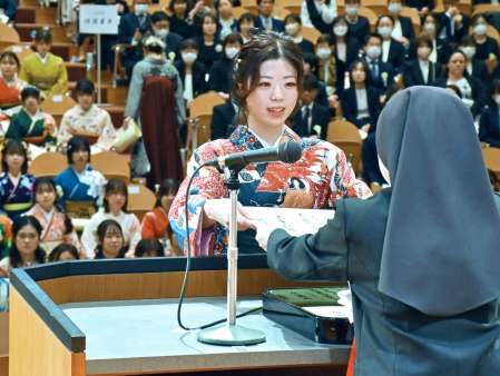 〈別カット〉笑顔で学位記を受け取る卒業生＝１５日、薩摩川内市の鹿児島純心大学