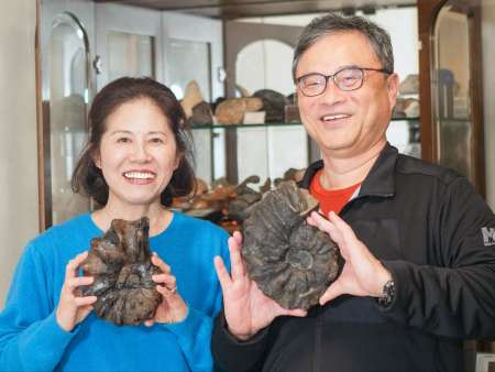 白亜紀のアンモナイトの化石を手にする筆者（右）と鹿屋市出身の妻・美穂