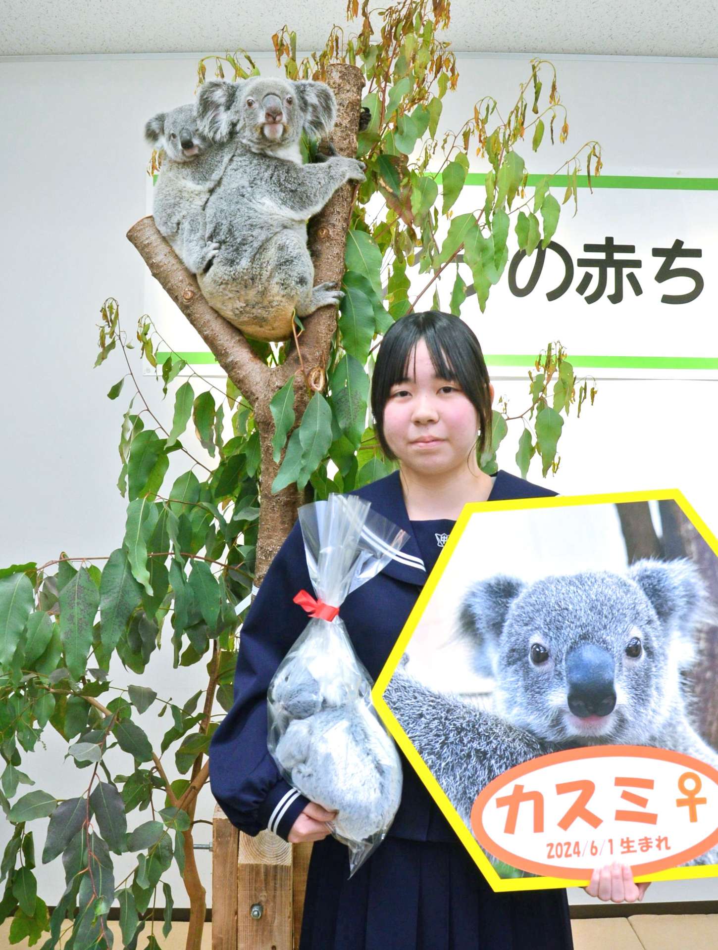 「カスミ」とヒマワリ親子と一緒に記念撮影する、名付け親代表の薄窪志歩さん＝２２日、鹿児島市の平川動物公園