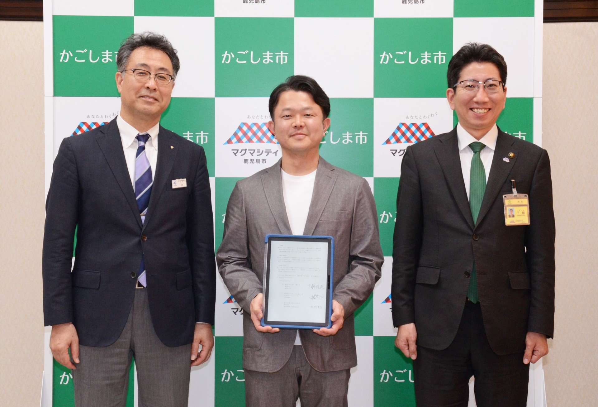 鹿児島市と工場増設の立地協定を結んだカゴシマパッカーズの木村良太社長（中央）＝２５日、市役所
