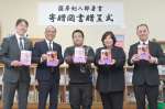 薩摩剣八郎さんの図書寄贈を喜ぶ出水市の関係者。中央が潟山類さん＝同市の江内中学校