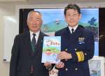 赤松宏樹本部長（右）から絵本を贈呈された荒木耕治町長＝鹿児島市の第１０管区海上保安本部