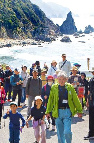 海岸沿いの絶景を眺めながら散策する参加者＝南さつま市笠沙町野間池