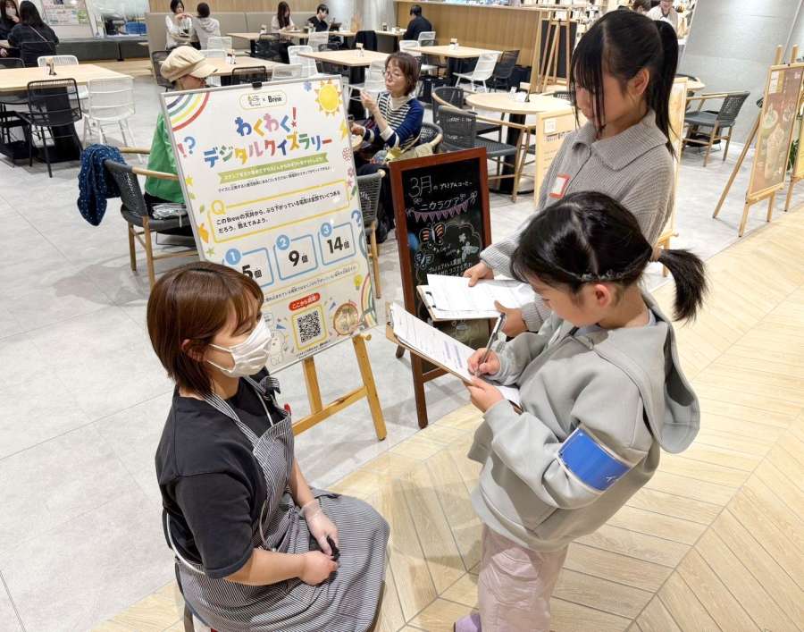 カフェの店員に取材する小学生＝３月２９日、鹿児島市の天文館図書館