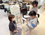 カフェの店員に取材する小学生＝３月２９日、鹿児島市の天文館図書館