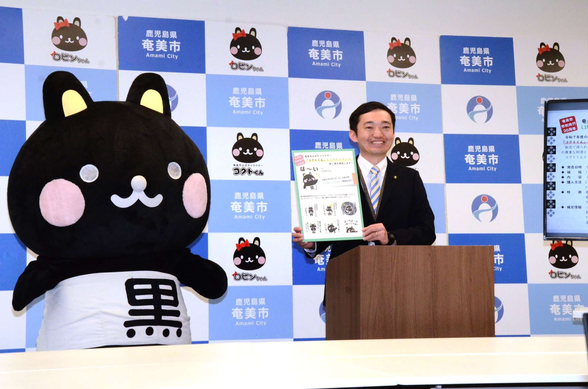 ＬＩＮＥスタンプをＰＲする奄美市の安田壮平市長とコクトくん＝２８日、奄美市役所