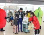 歓迎を受け、鹿児島の特産品が入った袋を受け取る台湾からの乗客＝３日、霧島市の鹿児島空港国際線ターミナル