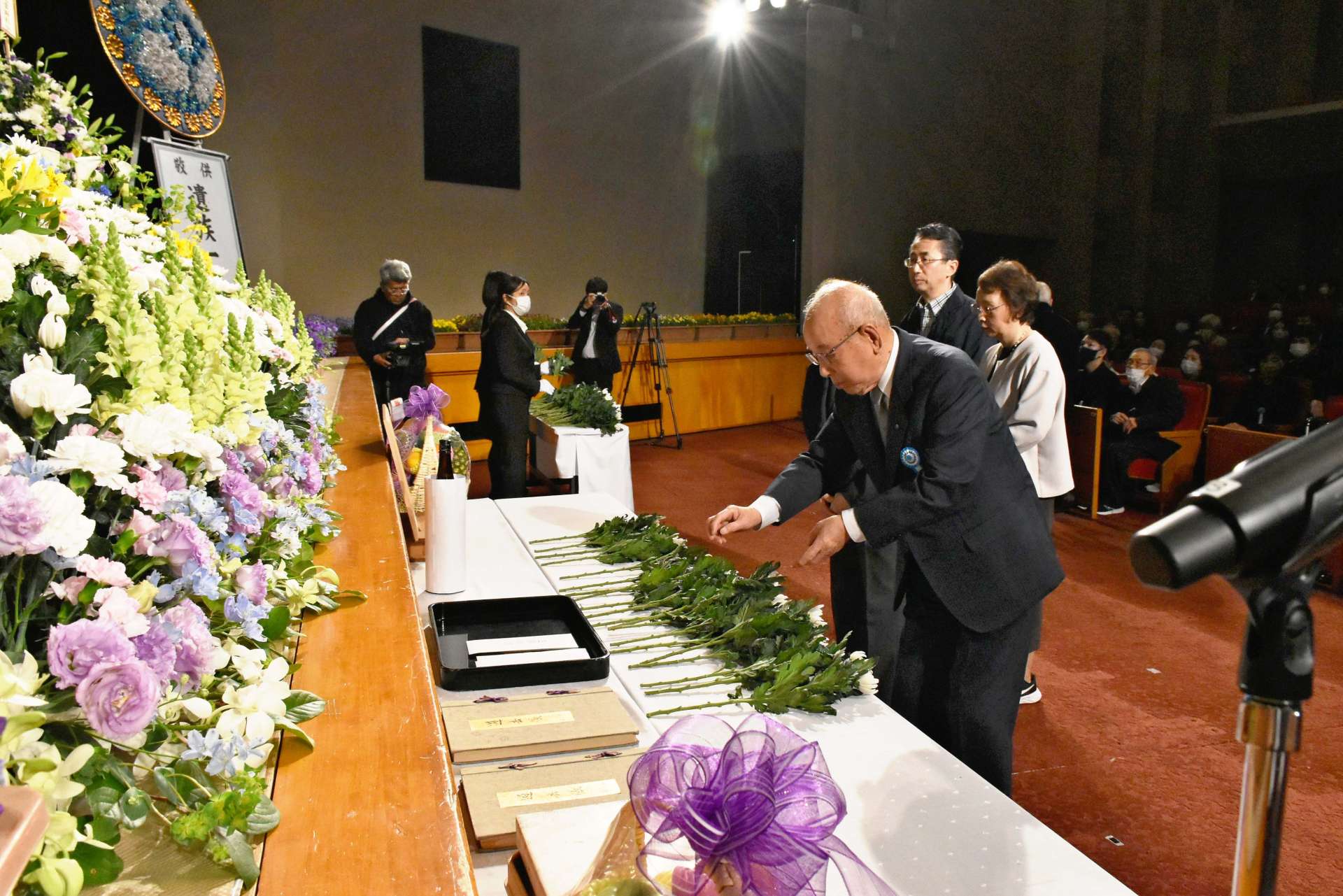 ２０２４年４月に行われた戦没者追悼式で献花する参加者＝鹿屋市文化会館