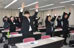 万歳三唱する新入社員＝８日、鹿児島市卸本町のオロシティーホール