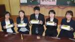巨大な豆腐で歓迎される野神小の先生たち＝１１日、志布志市有明の野神青少年館