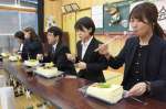 巨大な豆腐を味わう野神小の先生たち＝１１日、志布志市有明の野神青少年館