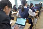 学習用端末を使って理科の試験に臨む中学生＝１４日午前、鹿児島市の伊敷中学校