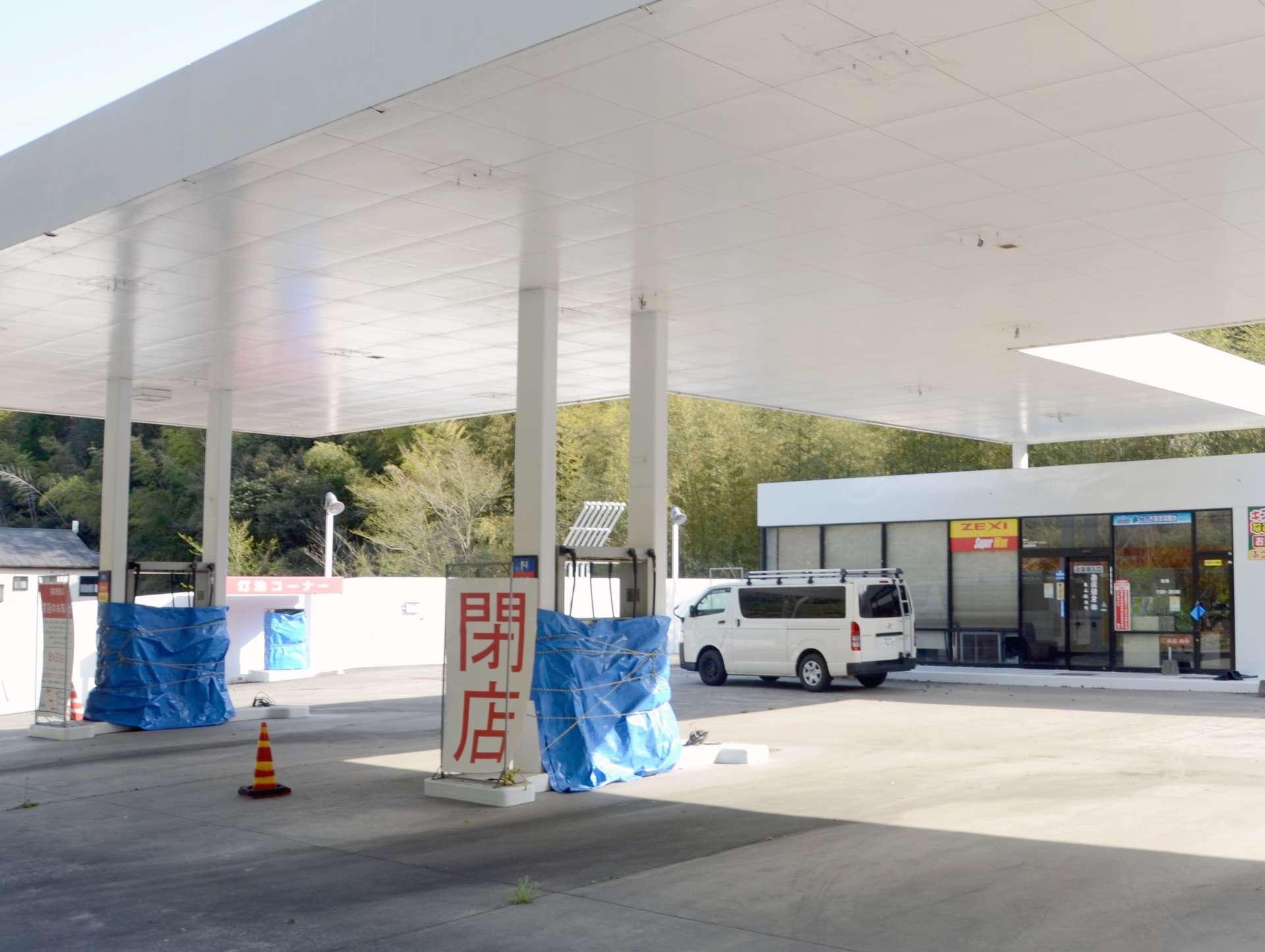 昨夏閉店したガソリンスタンド。給油ホースや洗車施設がそのまま残されていた＝４月上旬、鹿児島市春山町