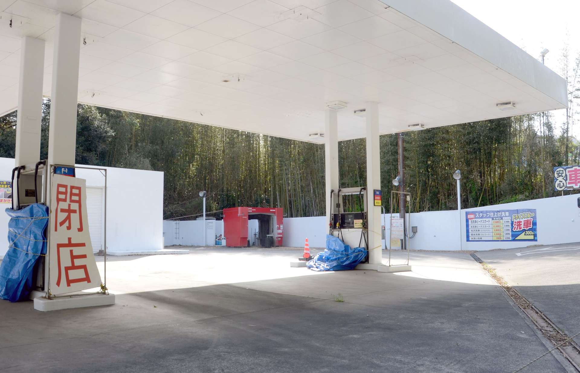 昨夏閉店したガソリンスタンド。給油ホースや洗車設備がそのまま残されていた＝４月上旬、鹿児島市春山町