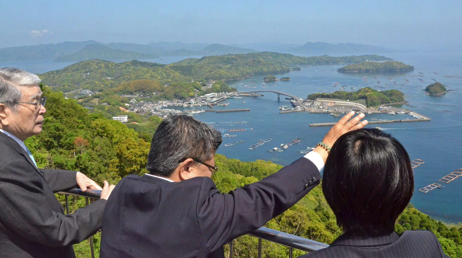 養殖ブリいけすについて説明を受ける自民党の野村哲郎参院議員（左）ら＝２１日、長島町の針尾公園
