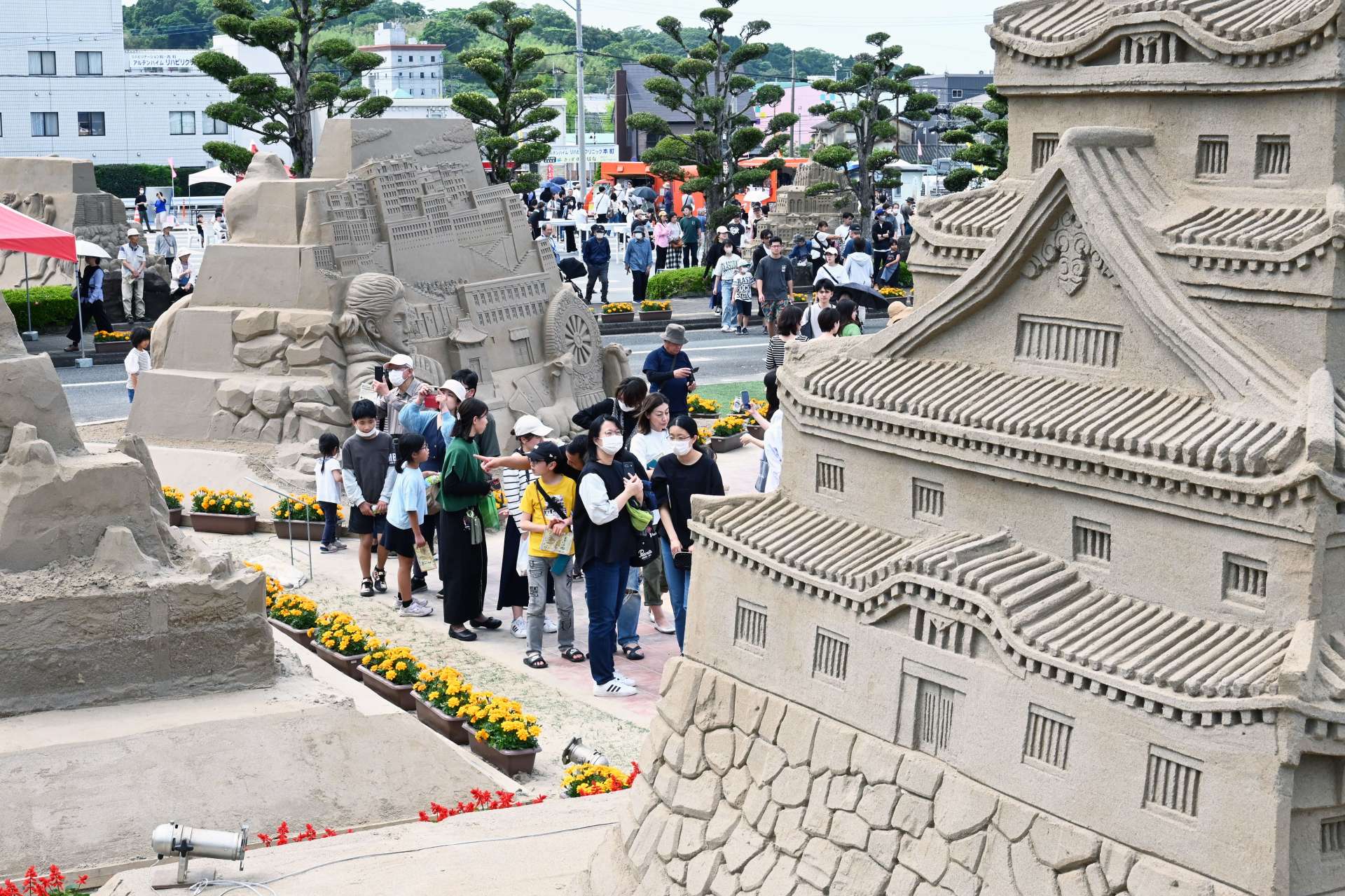 吹上浜砂の祭典会場でテーマに合わせて制作された砂像を楽しむ来場者＝２０２４年５月３日、南さつま市