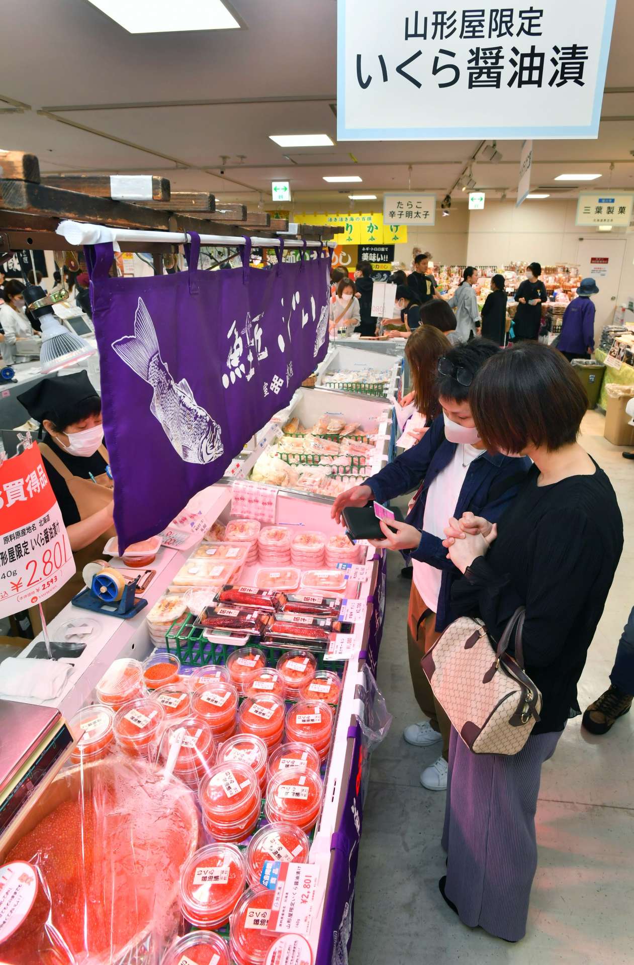 色鮮やかないくらに興味を示す来場者＝２３日、鹿児島市の山形屋