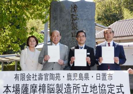 「樟脳製造創業之地」の記念碑前で記念撮影する１５代沈壽官さん（左から２番目）ら＝２４日、日置市東市来町美山