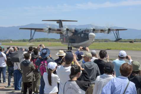海上自衛隊の救難飛行艇「ＵＳ２」を撮影する来場者＝２７日午後、鹿屋市の海上自衛隊鹿屋航空基地