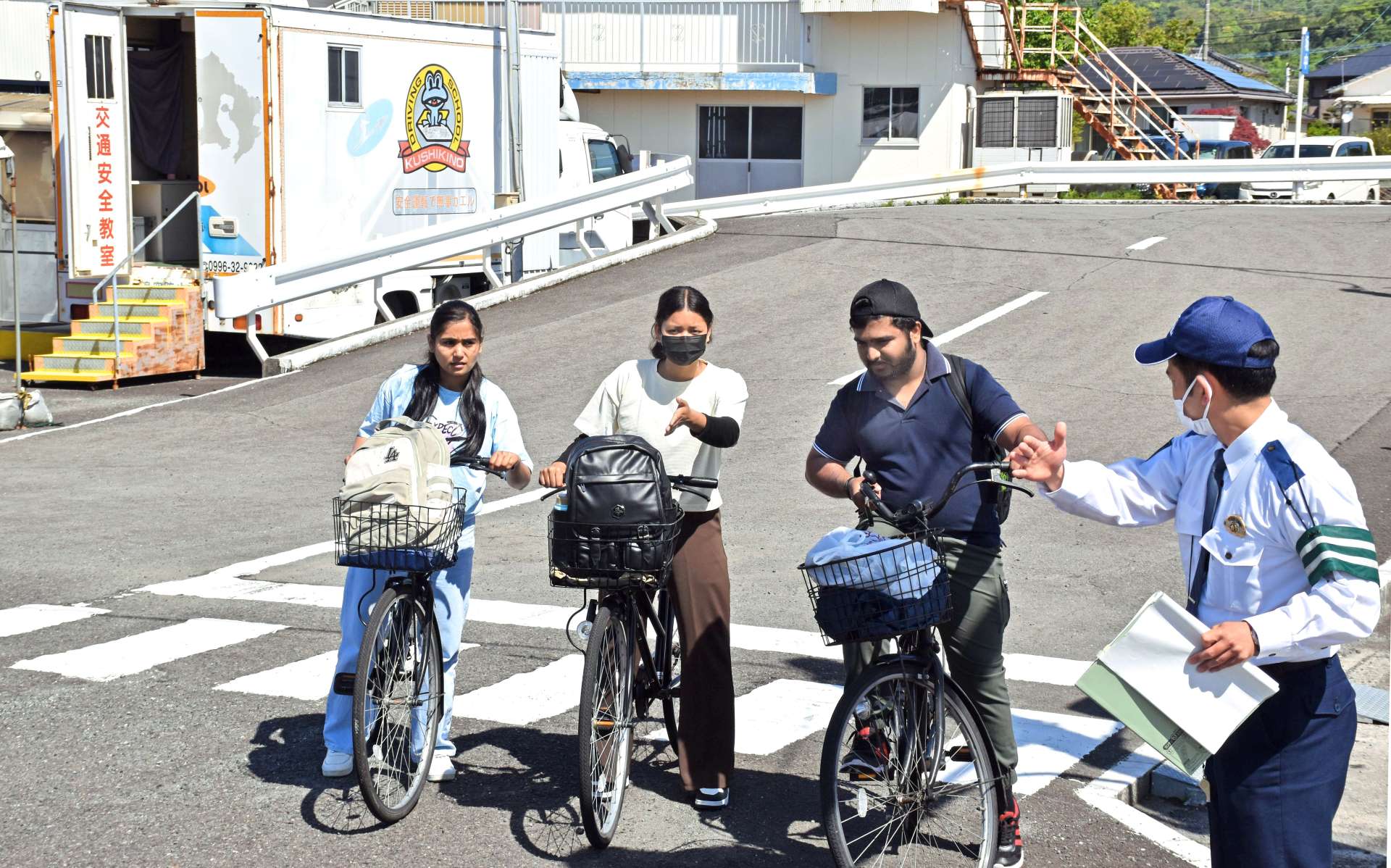 交差点での右折法について説明を受ける留学生たち＝いちき串木野市の串木野自動車教習所